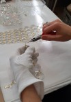 Travail à la main - Assemblage de pierres strassées à l'aide de minuscules papillons en laiton