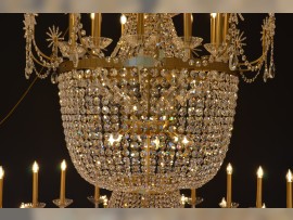 Détail de la partie supérieure du lustre. On y retrouve des bras tubulaires en laiton.