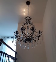 A dark brown chandelier made according to color of a wooden railing