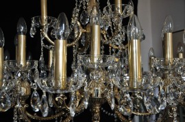 Detail of a large 28-bulb golden chandelier - cover tubes