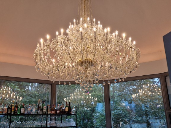 Effet miroir étonnant d'un lustre en cristal dans les fenêtres d'un café